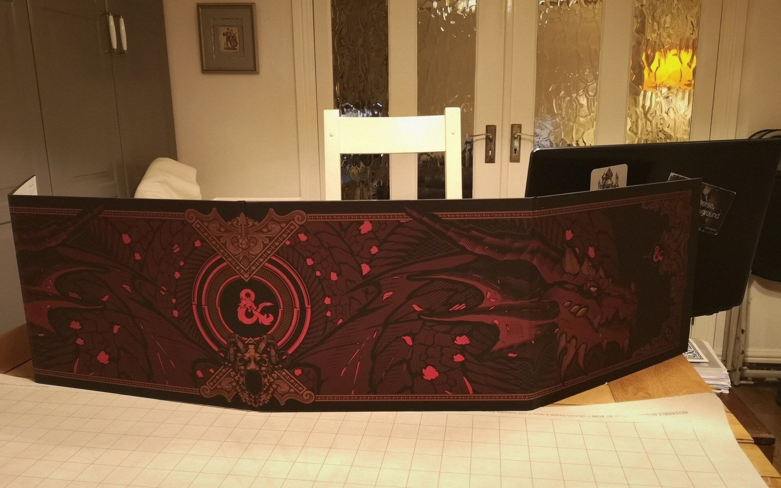 A red and black Dungeons & Dragons dungeon master's screen standing on a table